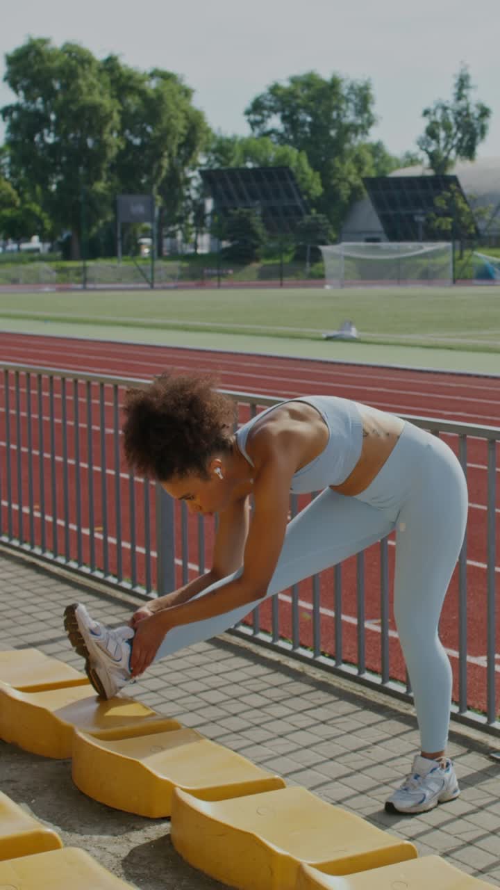 mujer estirándose en un estadio