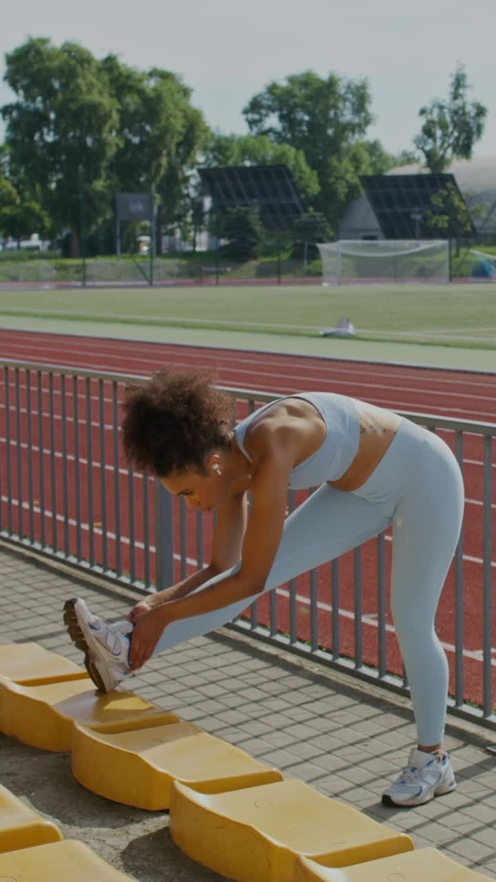 Woman Stretching at a Stadium