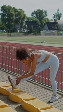 woman stretching at a stadium