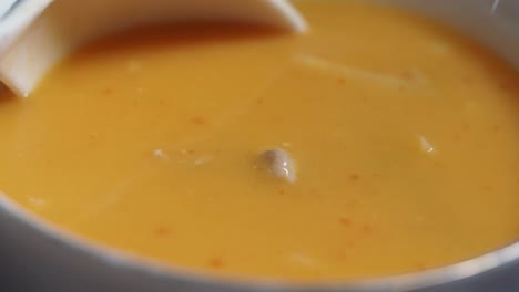 orange soup in a bowl with spoon
