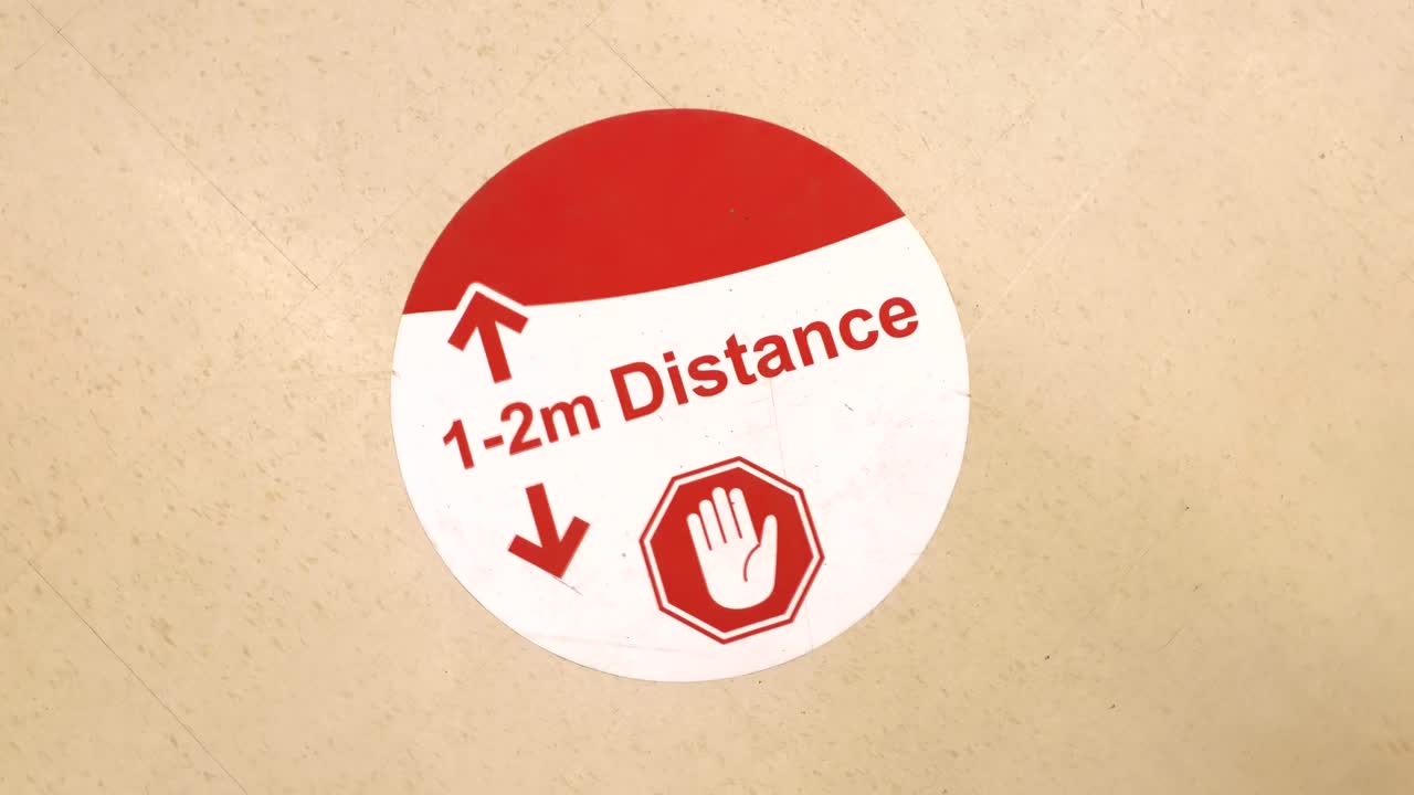 señal de advertencia de coronavirus de 1-2 m en el piso de la tienda de comestibles