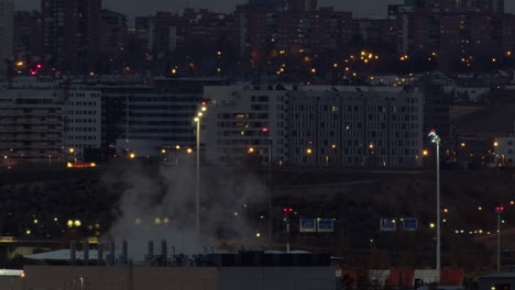 Evening-Madrid-view-with-apartment-houses-and-working-plant