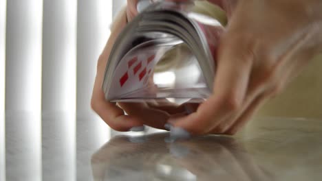 Girl-with-painted-nails-shuffles-playing-cards