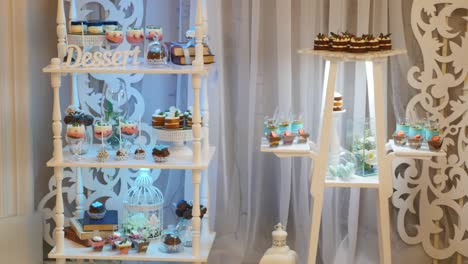 delicious wedding reception candy bar dessert table inside of the celebration hall