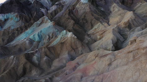 aerial drone shot flies over the beautiful artist's pallette along artist's drive in death valley, california