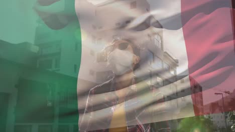 Animation-of-flag-of-italy-over-woman-wearing-face-mask
