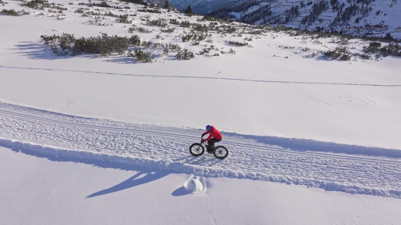 Vista aerea di un tour invernale in fatbike con turisti sulle colline austriache innevate