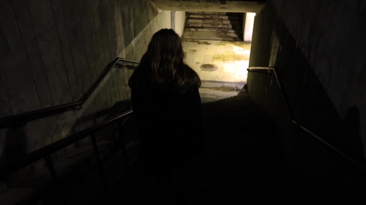 Girl walking down to the underground passage at night