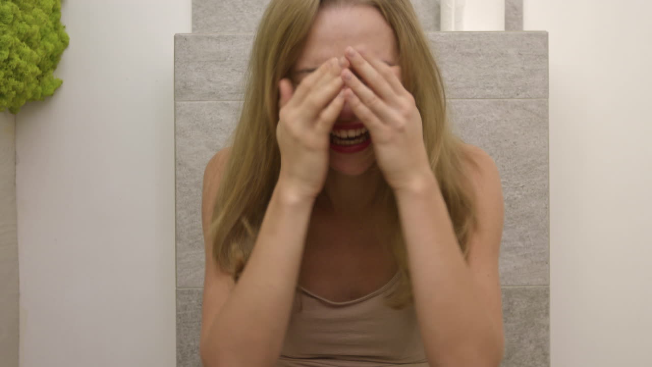 mujer desesperada está sentada en el baño llorando, plano medio