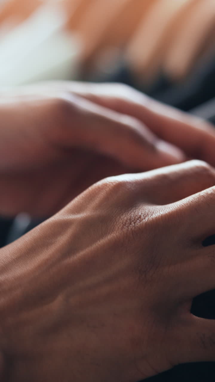 Close Up of Hands Touching and Selecting Clothes on Hangers