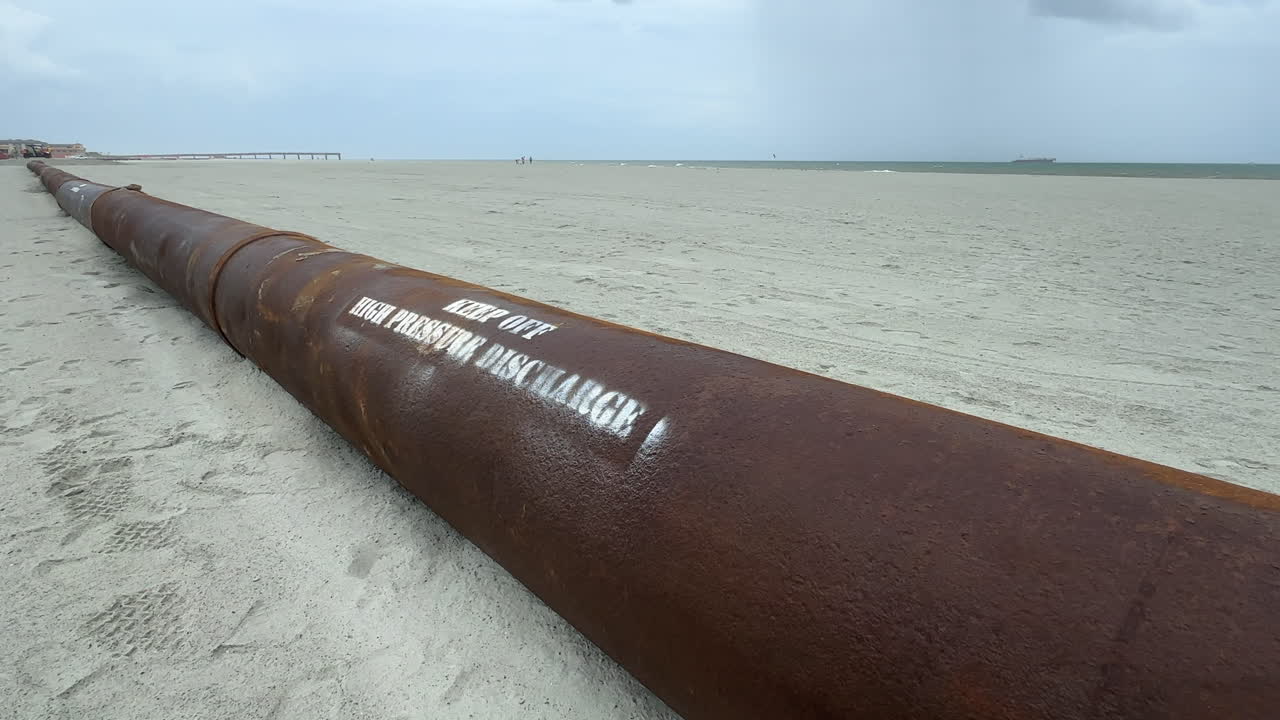 Pipe pumping sand from ocean, beach replenishment, close up