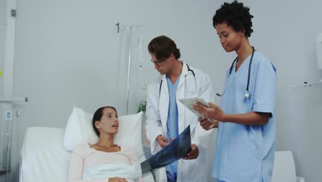 front view of multi-ethnic male and female doctor showing medical report to patient in ward 4k