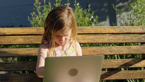 Girl-using-laptop-in-the-garden-4k