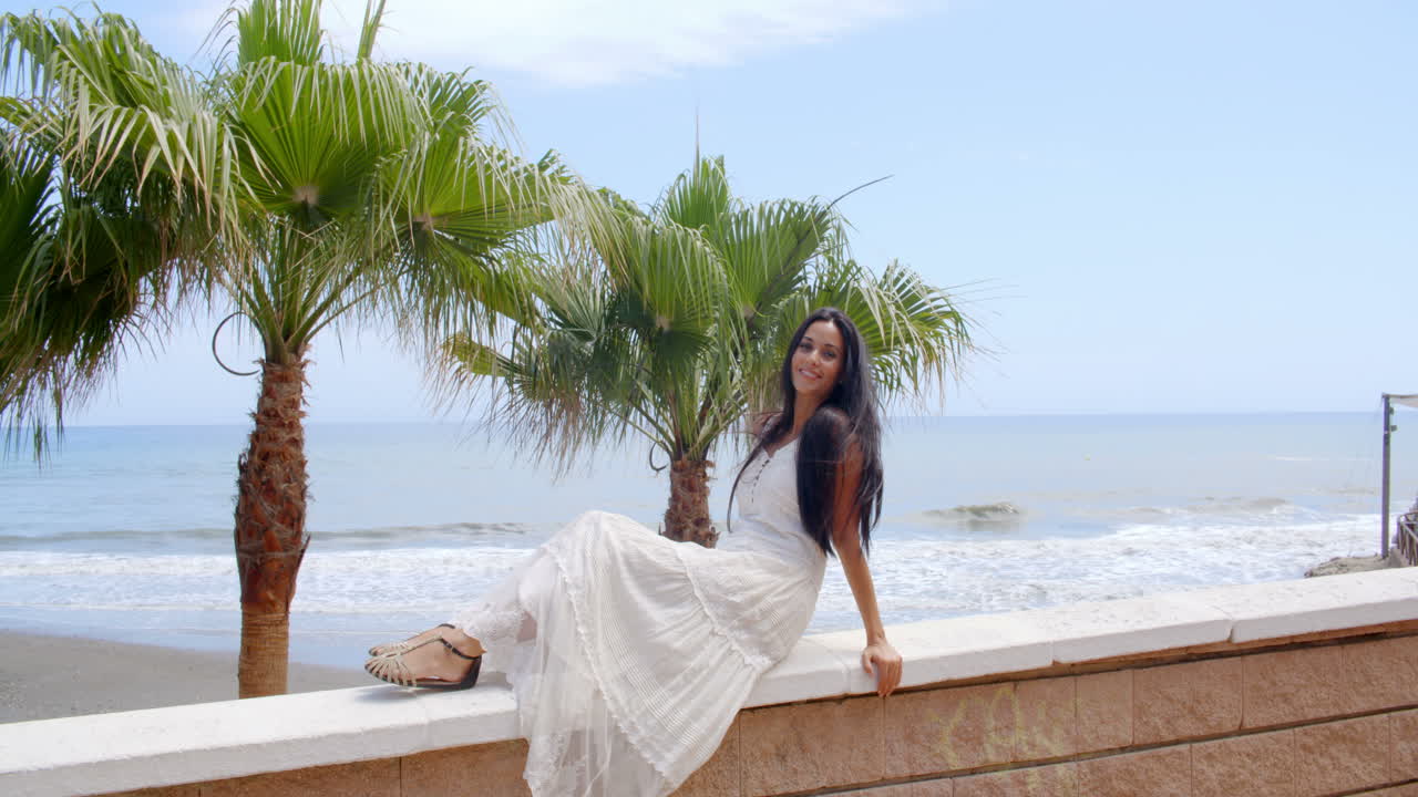 joven relajándose en los rieles del balcón en la playa