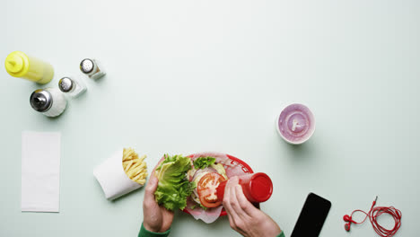 Top-view-man-eating-burger-at-american-diner-fast-food-restaurant-hands-from-above---Red-Epic-Dragon