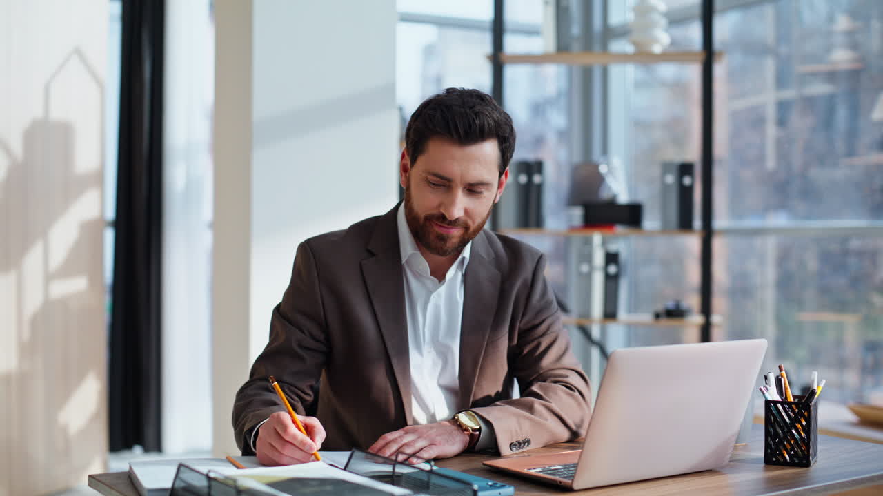 Business owner writing notebook browsing laptop data sitting office closeup