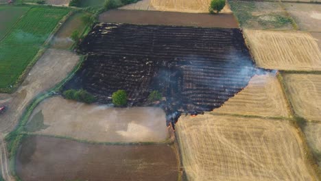 aerial drone shot of stubble burning of left overs from wheat field harvest causing smog and heavy air pollution in north india