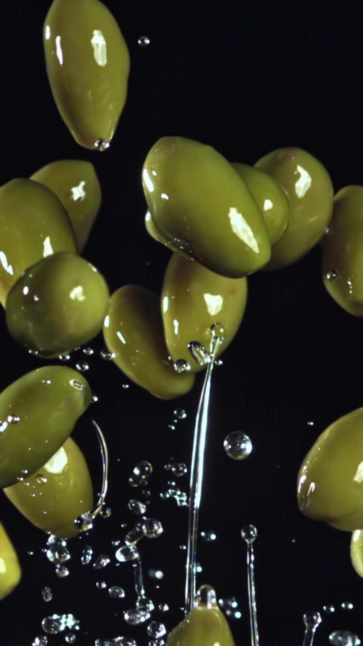 Olive verdi che risalgono con spruzzi d'acqua al rallentatore