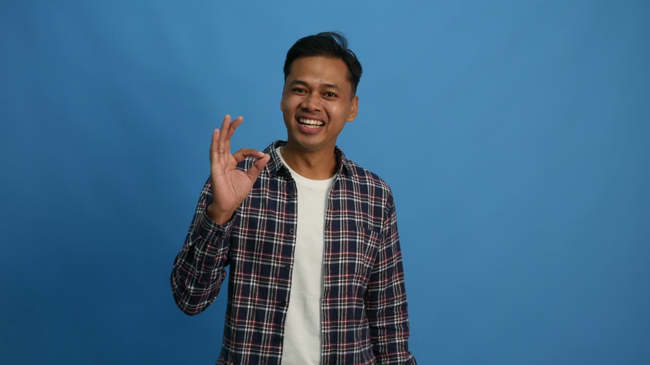 Smiling fun young man. Looking camera approvingly say wow it is ok showing okay sign gesture. People lifestyle concept