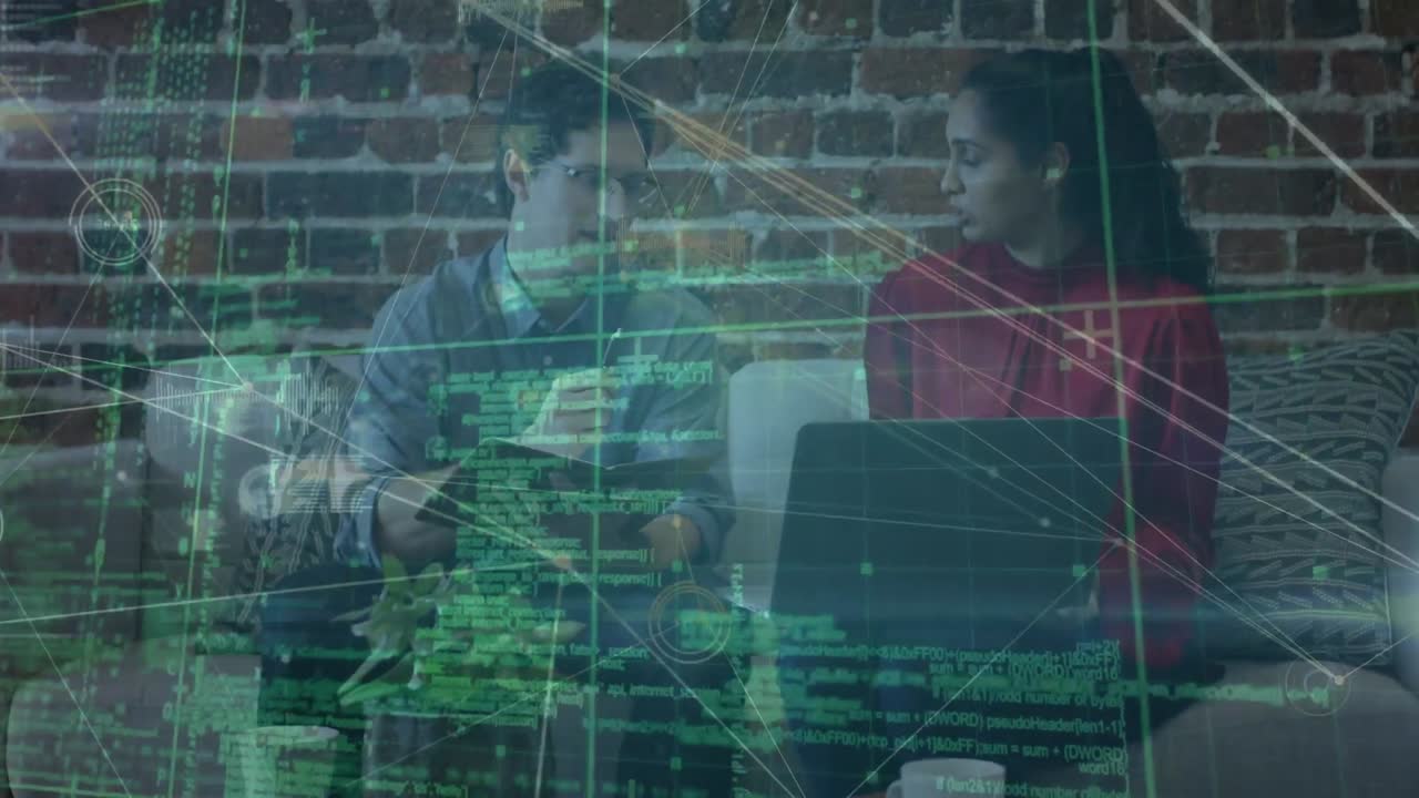 Animation of dots connecting with lines and codes over caucasian colleagues discussing on sofa