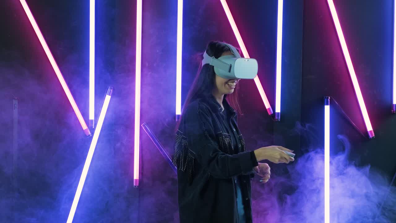 giovane donna che gioca a sparatutto nella realtà virtuale. casco di realtà virtuale su sfondo di luce a colori fumo
