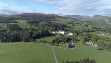 high aerial shot and push in towards blair castle over green fields and gardens