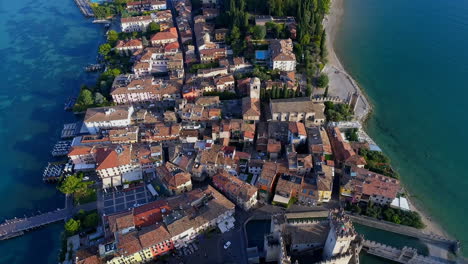 aerial view of beautiful cityscape with houses and forest surrounded by sea