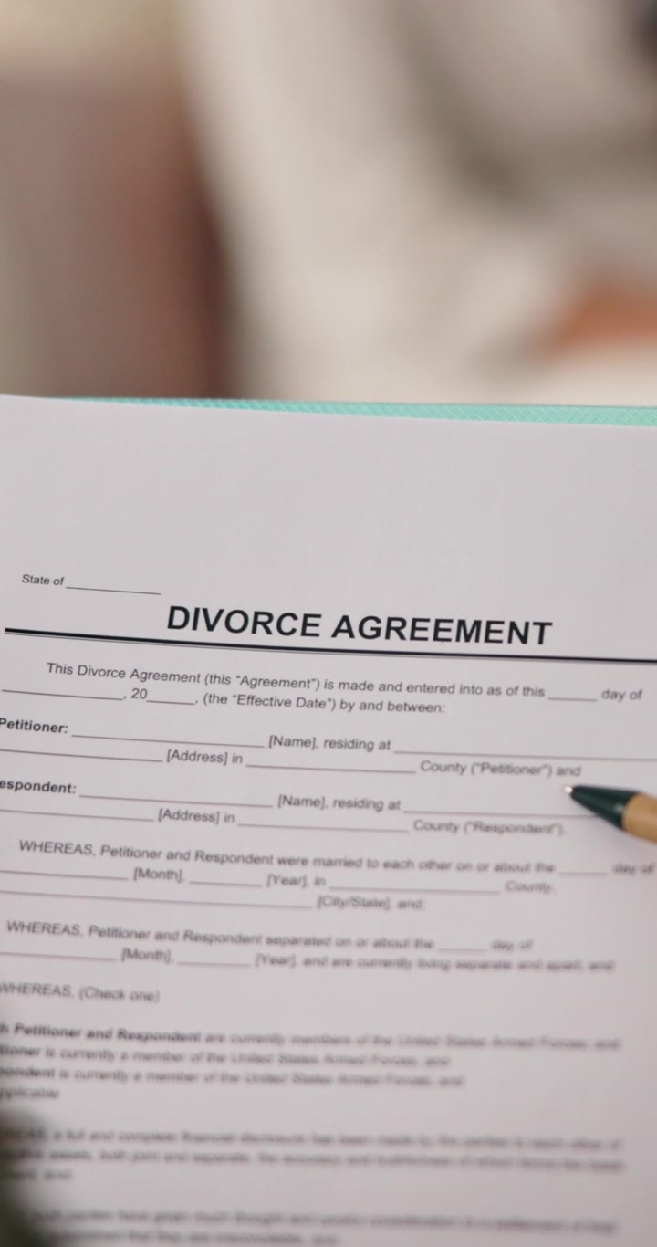 Person Pointing at Divorce Agreement Document with Pencil