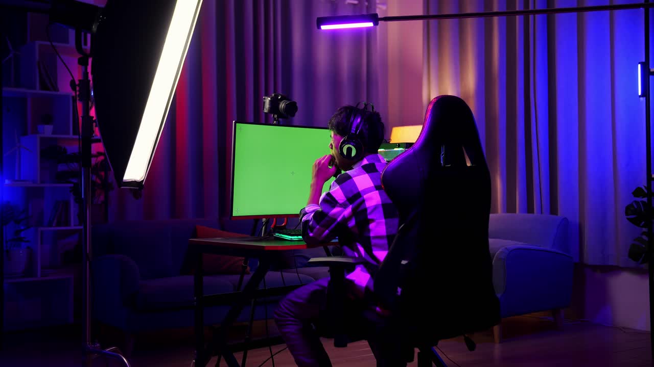Back View Of Asian Boy Streamer Using Green Screen Personal Computer. Yawning And Sleeping, Desk Illuminated By Rgb Led Strip Light