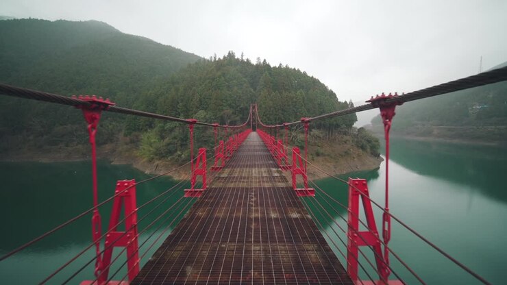 Point de vue d'une personne traversant le pont suspendu de Zaobashi au-dessus de la rivière Arita par une journée brumeuse dans la préfecture de Wakayama, Japon