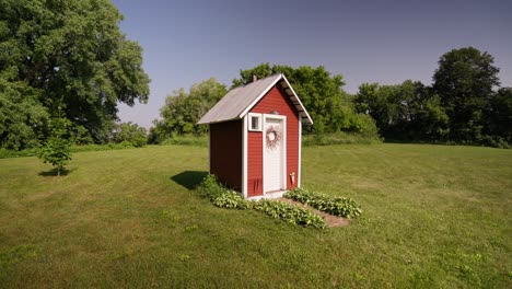 wide push in shot of the exterior of a red out house