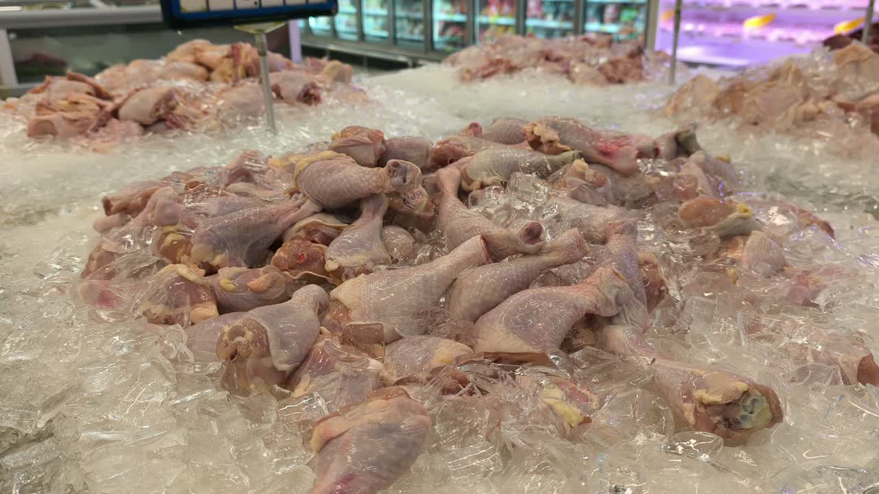 Cut chicken portions are separated and placed on ice for sale. These parts are displayed in the wet market section of a supermarket. Prices are determined by the weight and type of chicken piece