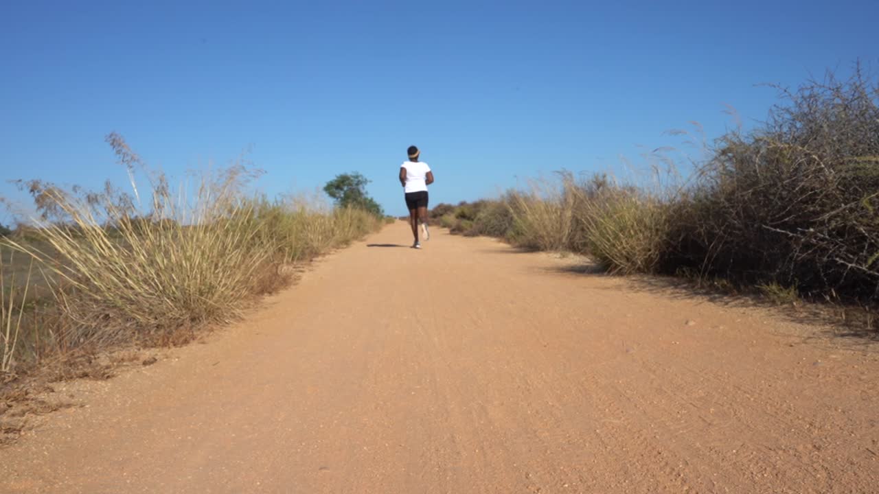 mujer negra corriendo en la arena