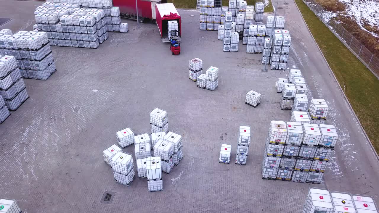 상자와 포장재가 쌓여 있는 선반 사이를 운전하는 창고의 지게차 운전사