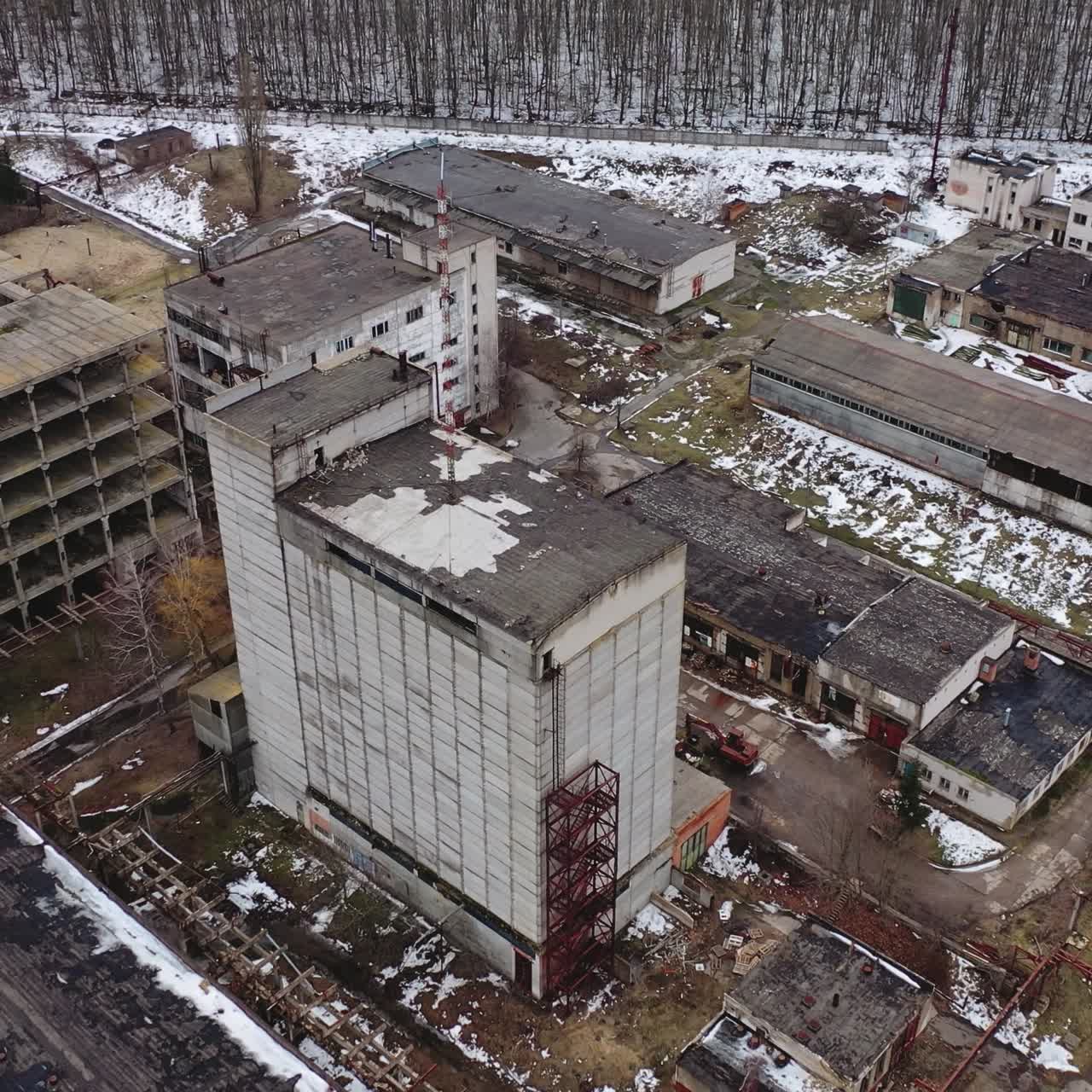 Ruined factory in winter time. Abolished buildings of industry. Empty abandoned place. Industrial edifices for demolition. Aerial view