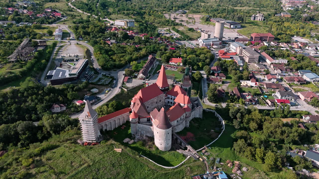 Aerial view of Corvin Castle in Hunedoara during sunny day with lush greenery