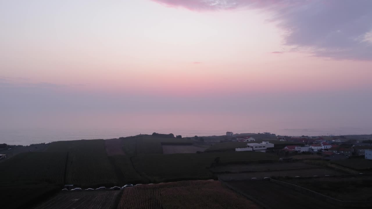 Pastel sunset sky above quiet coastal village and fields near Castro de São Paio beach