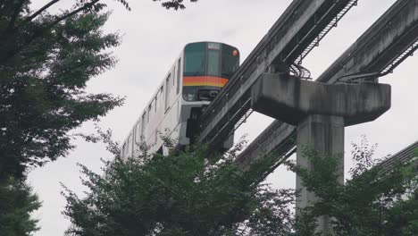 a monorail train passing by in the city of tokyo, japan at daytime