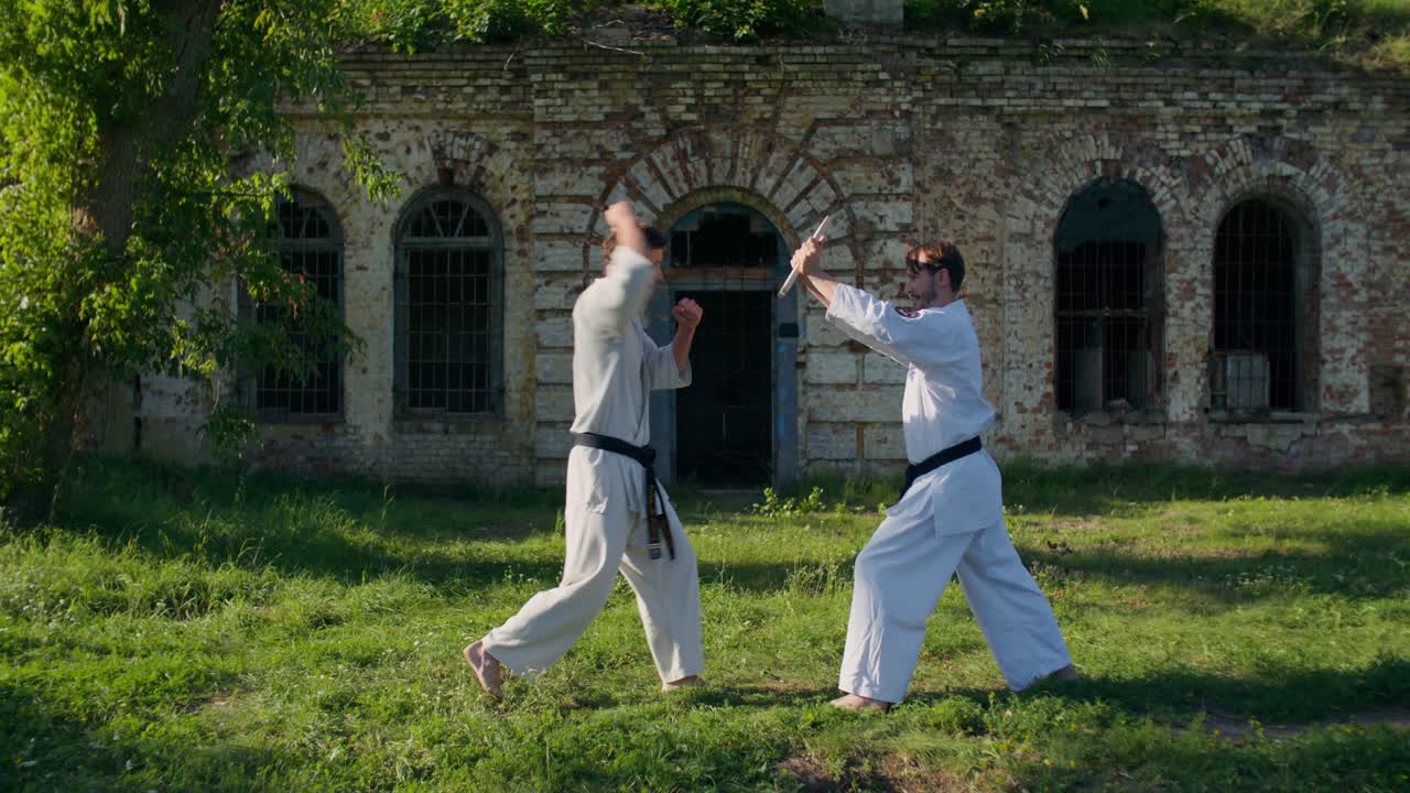 Due uomini che praticano karate all'aperto