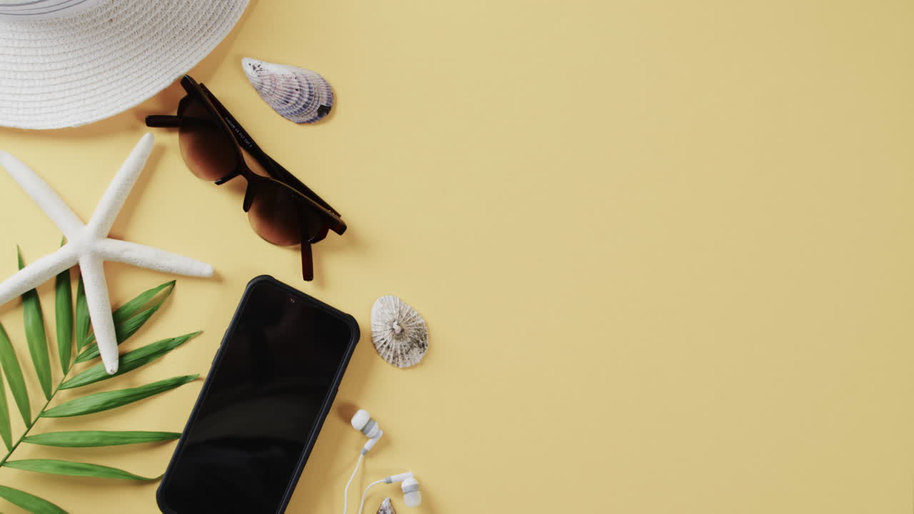 primer plano de proyectiles, teléfonos inteligentes y gafas de sol con espacio de copia sobre fondo amarillo.