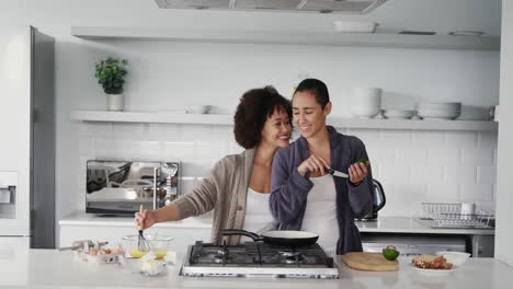 pareja de lesbianas preparando el desayuno en la cocina