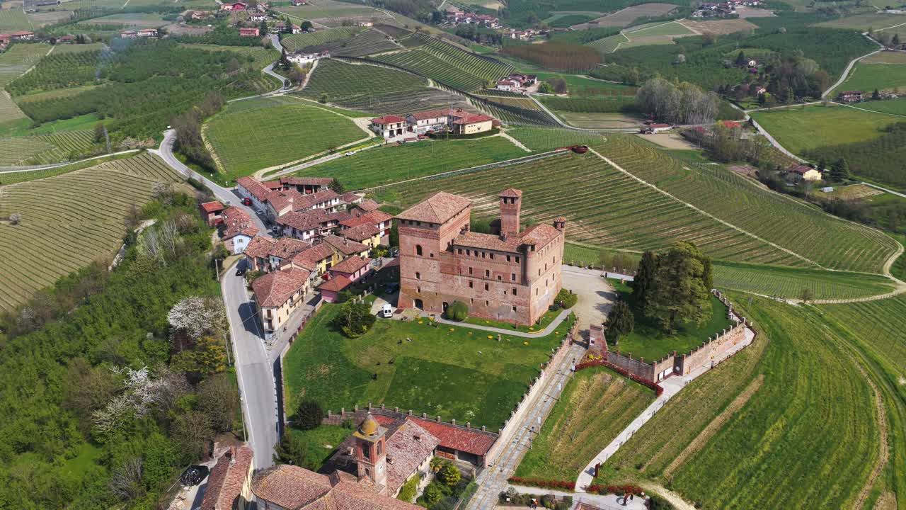 Aerial footage of Grinzane Cavour castle surrounded by vineyards and rolling hills, showcasing historic architecture, scenic countryside, and charming village life in the heart of Piedmont