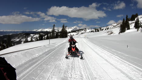 snowmobiling in the mountains. snowmobile coming towards camera in motion.