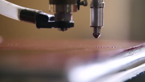 a mechanical braille drill inserts braille dots into pre-drilled holes