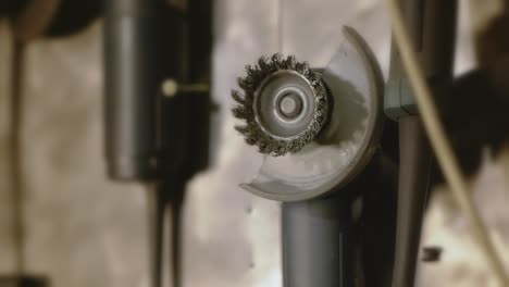 rack focus on an electric grinder hanging on the wall in the workshop