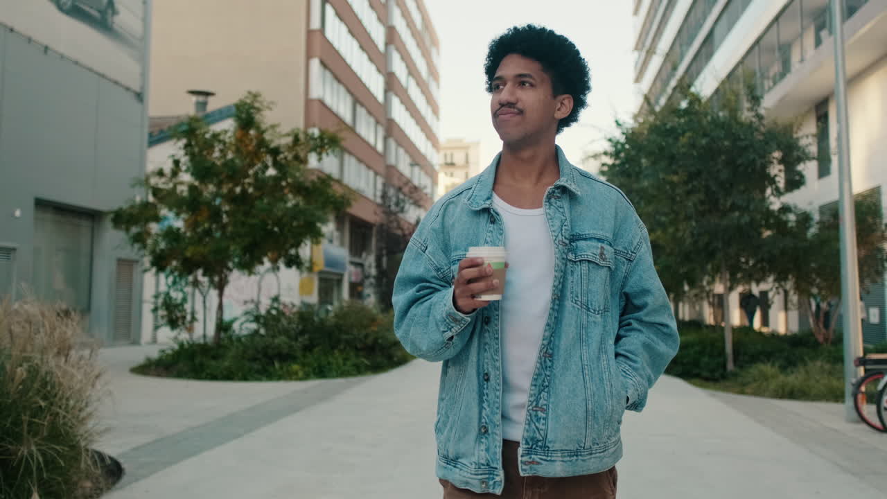Mand, der går ned ad gaden med en kop kaffe