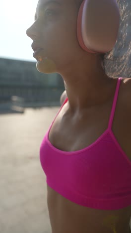 young woman in sports bra listening to music