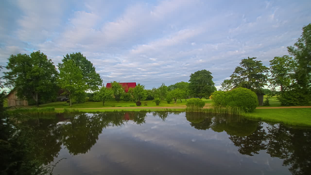 아름다운 호수, 울창한 농장, 빨간 지붕의 창고, 나무, 물 속의 구름의 반사, 오후부터 일몰, 루프