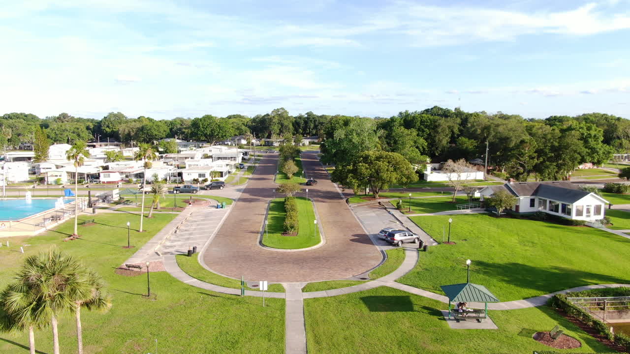 Flying out of a park above the trees and lakeside neighborhoods on a spring evening in Florida