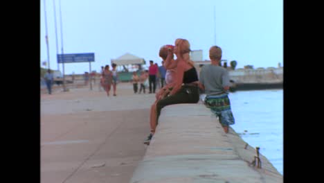 la gente se sienta a lo largo de la costanera en la habana cuba en la década de 1980